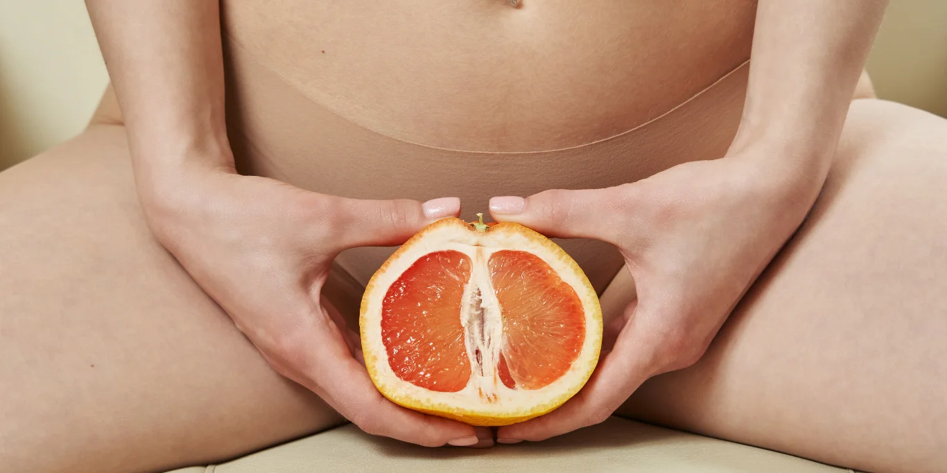 female body and a cut half of a grapefruit