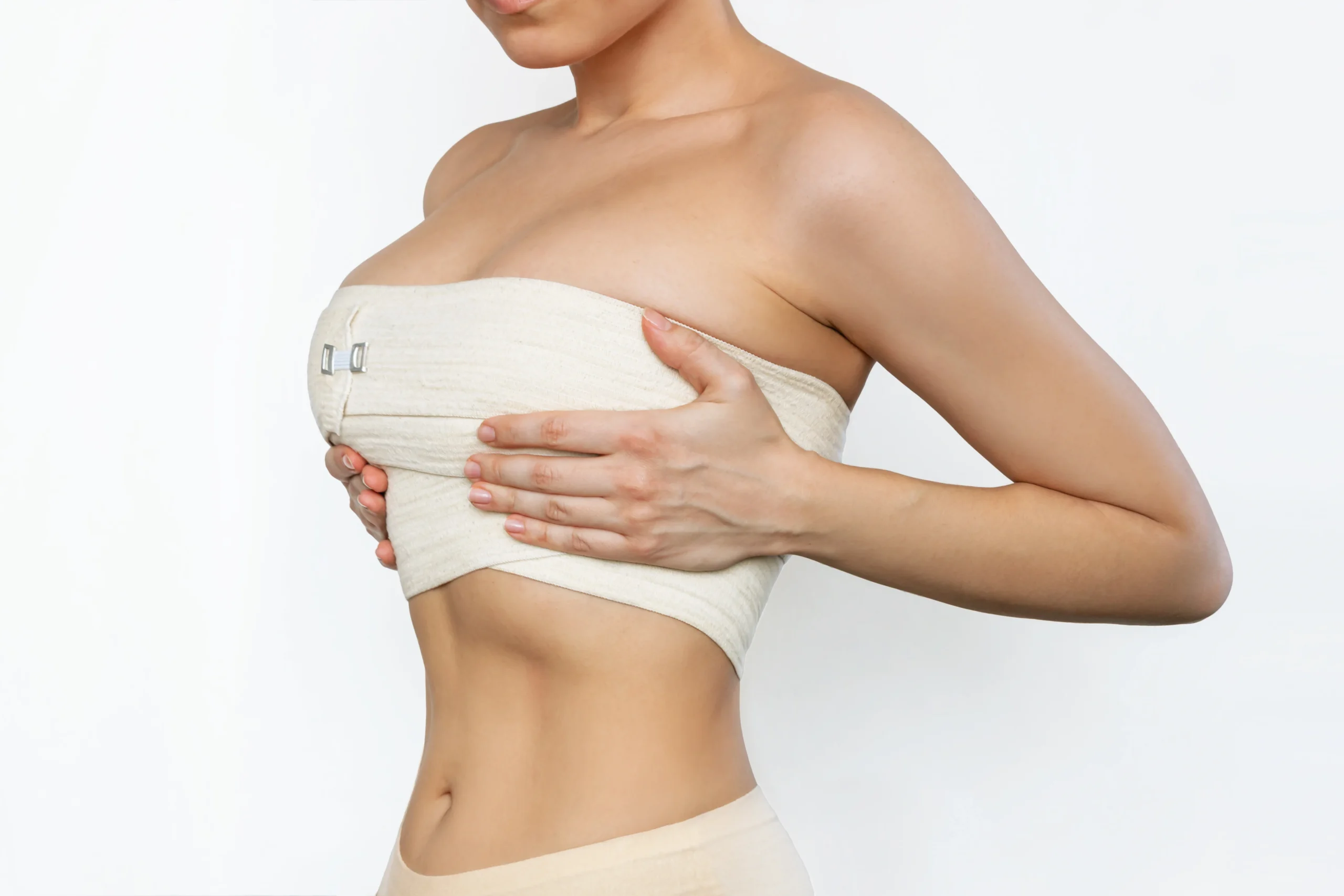shot of young fit woman wrapped in elastic bandage after breast augmentation shot of young fit woman wrapped in elastic bandage after breast augmentation